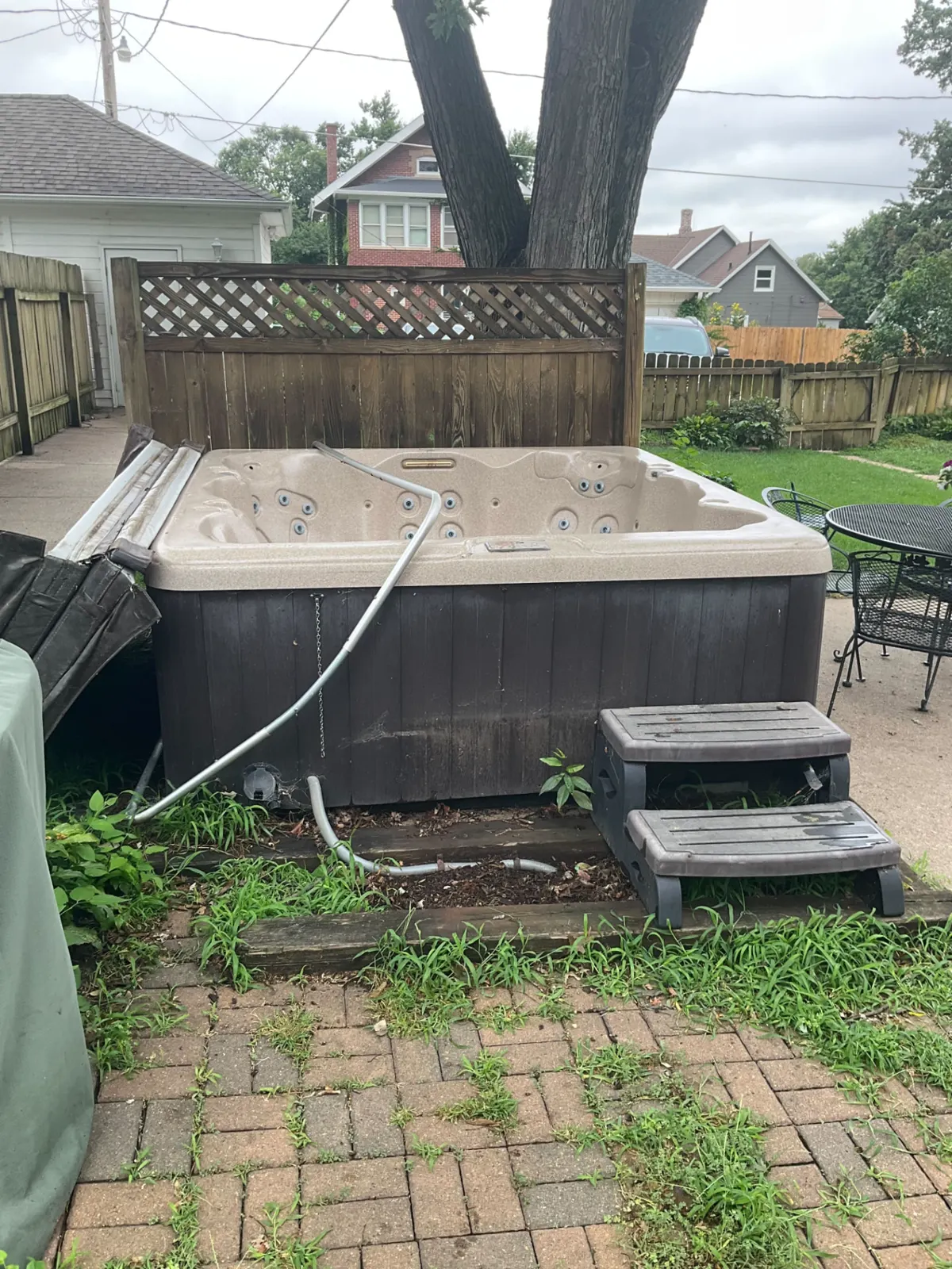 Old hot tub on a backyard patio ready for removal in Omaha