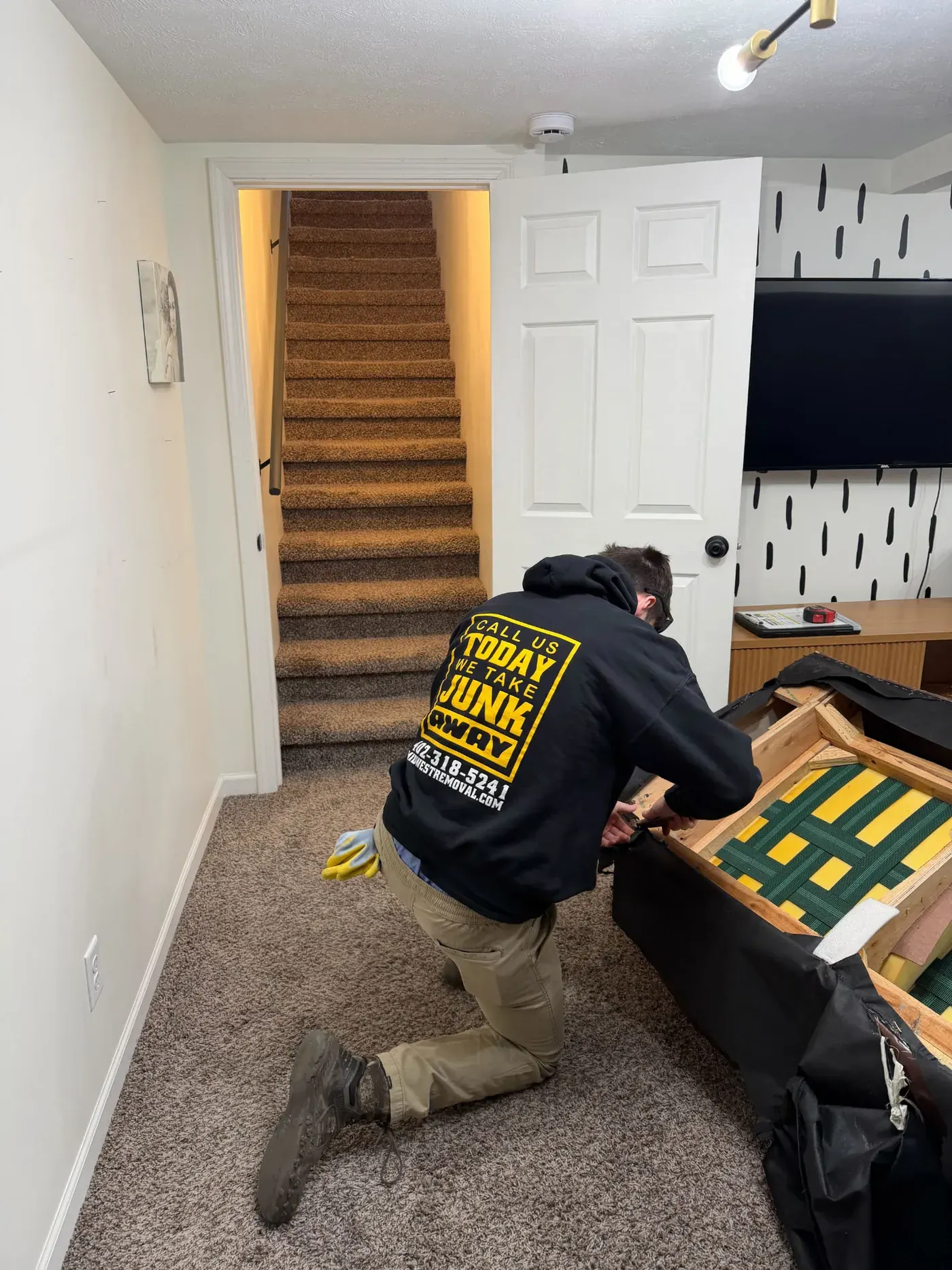 Cutting down a basement couch for removal, Omaha