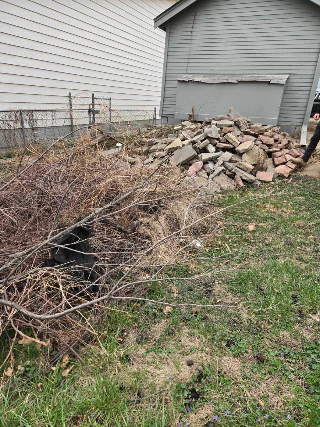 Broken concrete, stone and brush piled beside an Omaha home