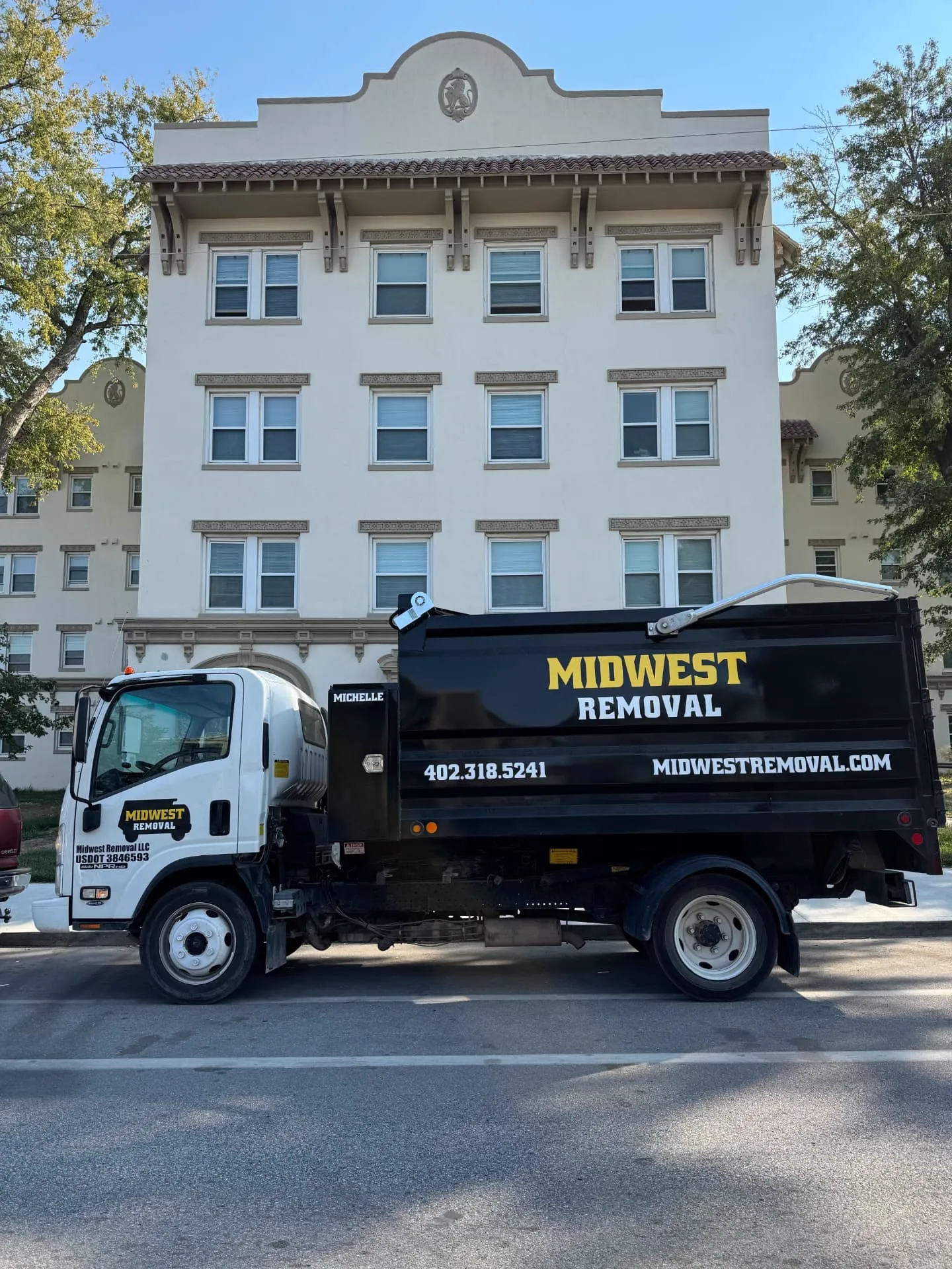 Midwest Removal truck outside a multi-unit apartment building