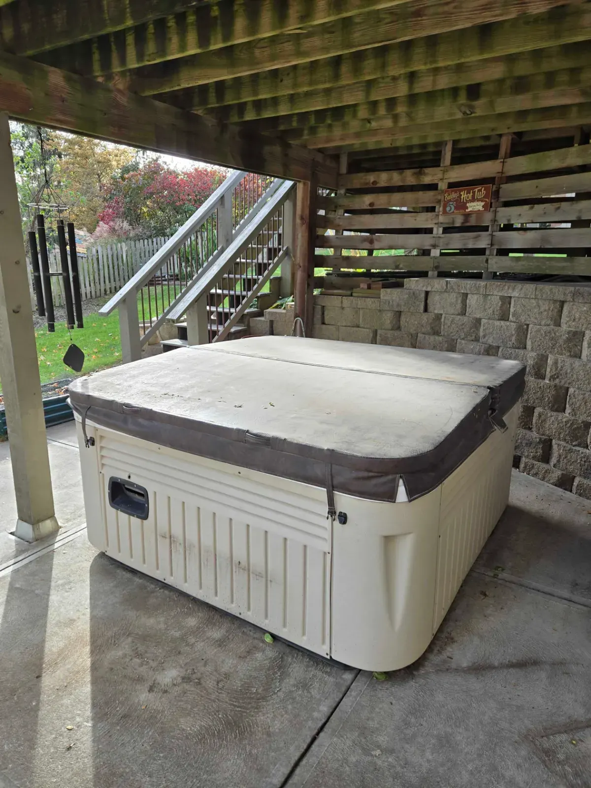 Covered hot tub under a deck, ready for haul away, Omaha