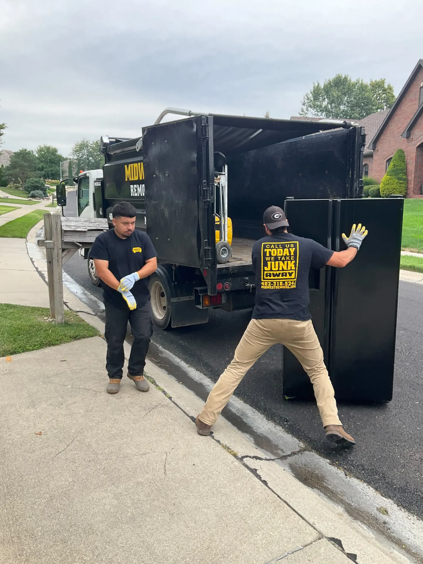Crew wheeling a refrigerator out to the truck, Gretna