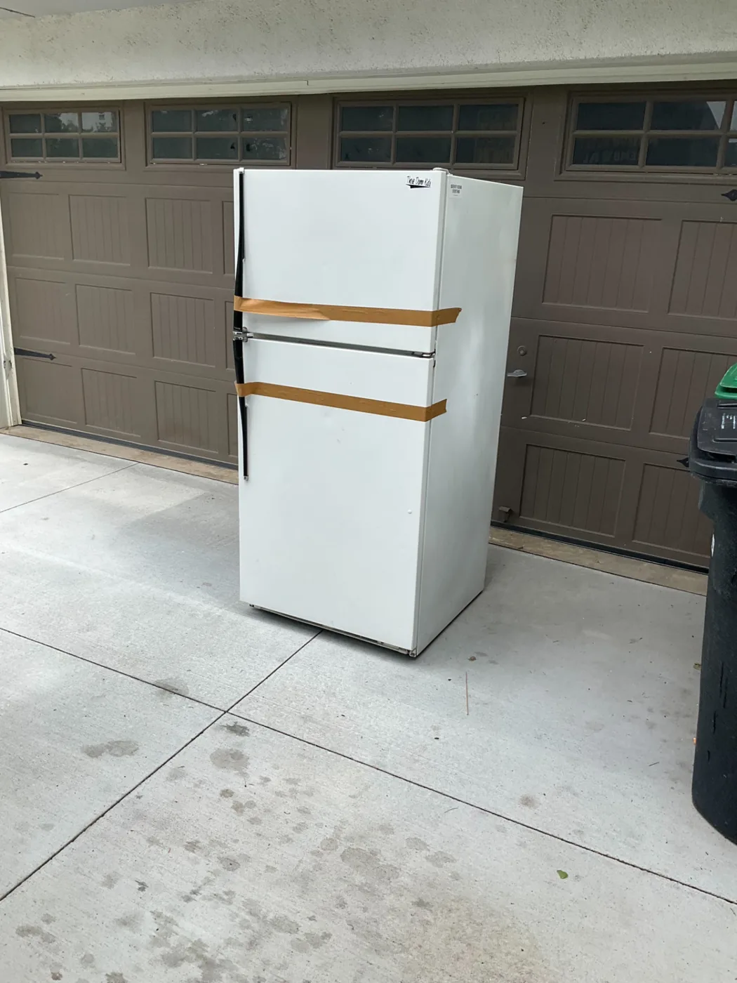Old fridge taped shut and set out in the driveway, Omaha