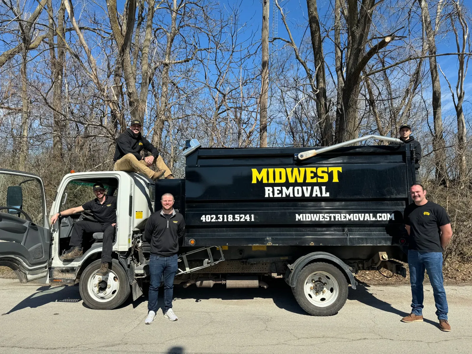 Midwest Removal crew standing with their junk removal truck in Omaha