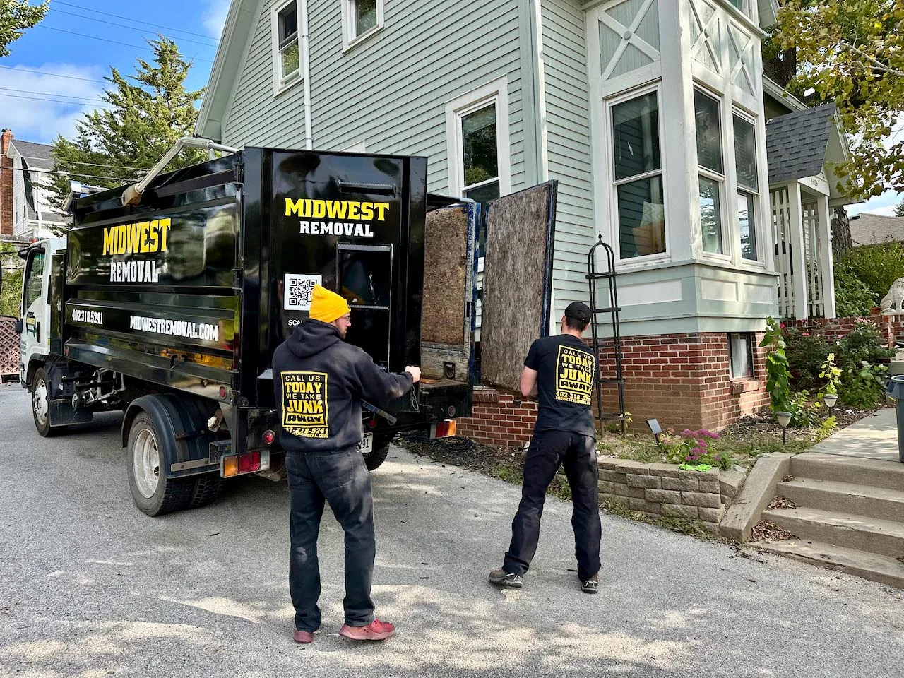Crew loading a curbside pile into the truck, Omaha
