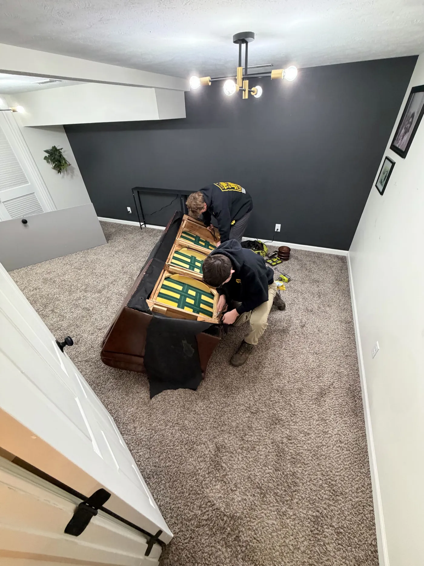 Crew breaking down a couch in an Omaha basement