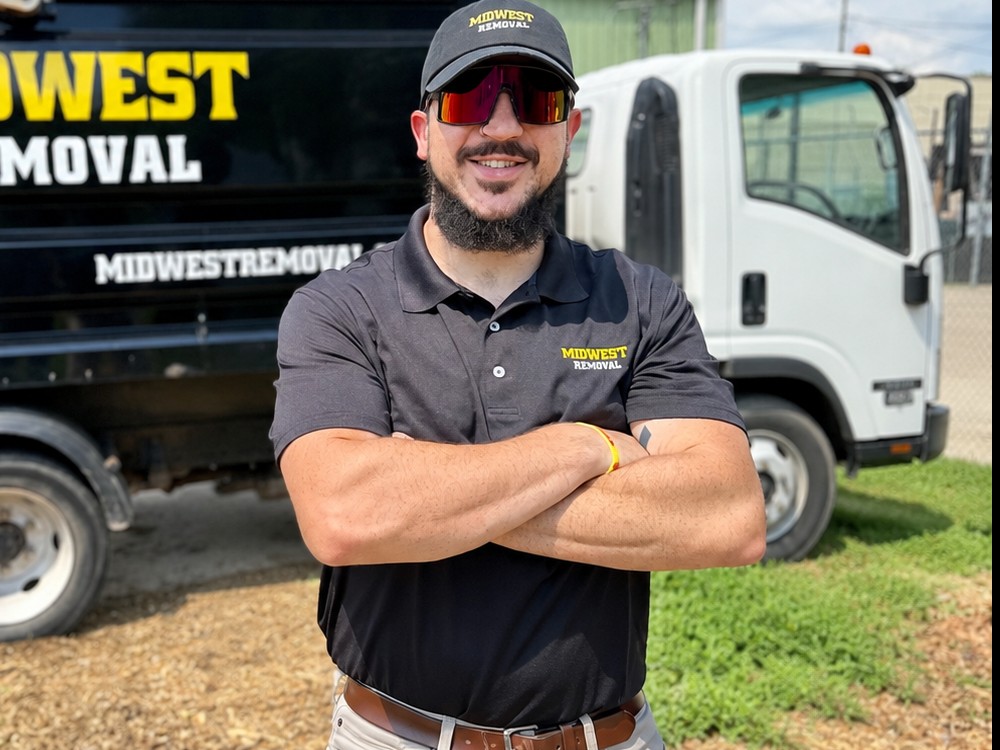Midwest Removal team member standing in front of the company trucks in Omaha