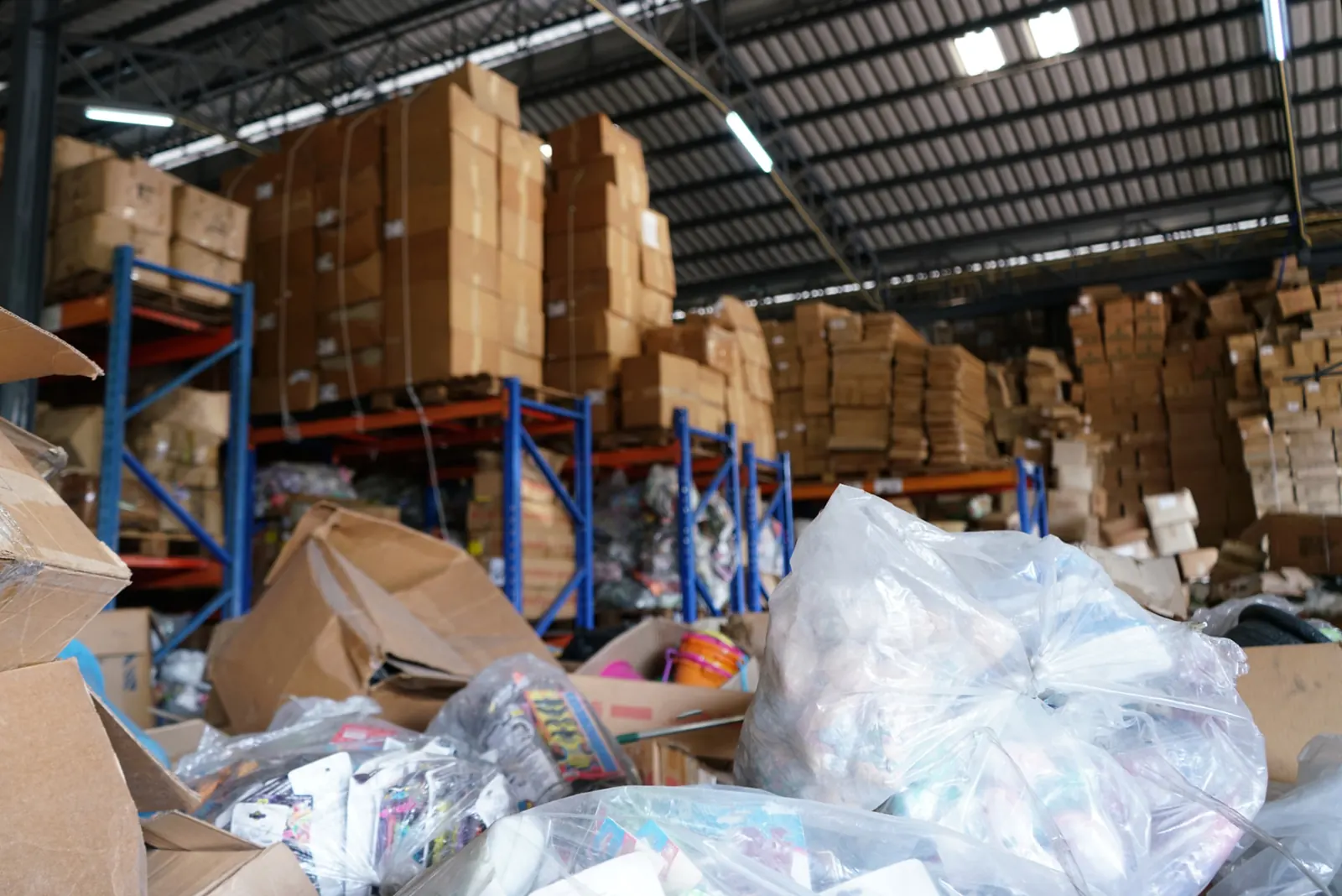 Boxes, pallet racking and bagged waste piled up inside a warehouse