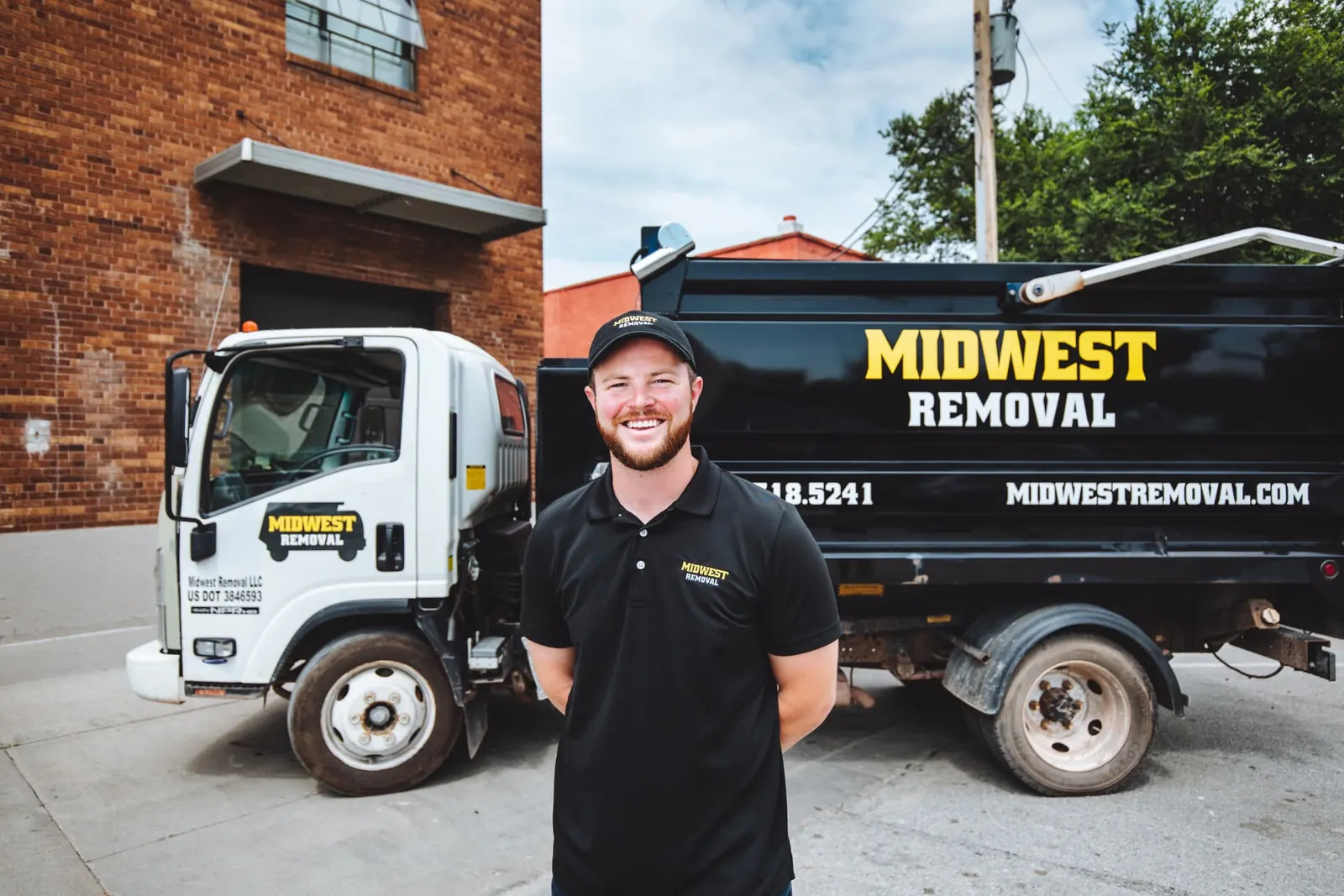 Midwest Removal crew loading a mattress into their truck outside an Omaha home