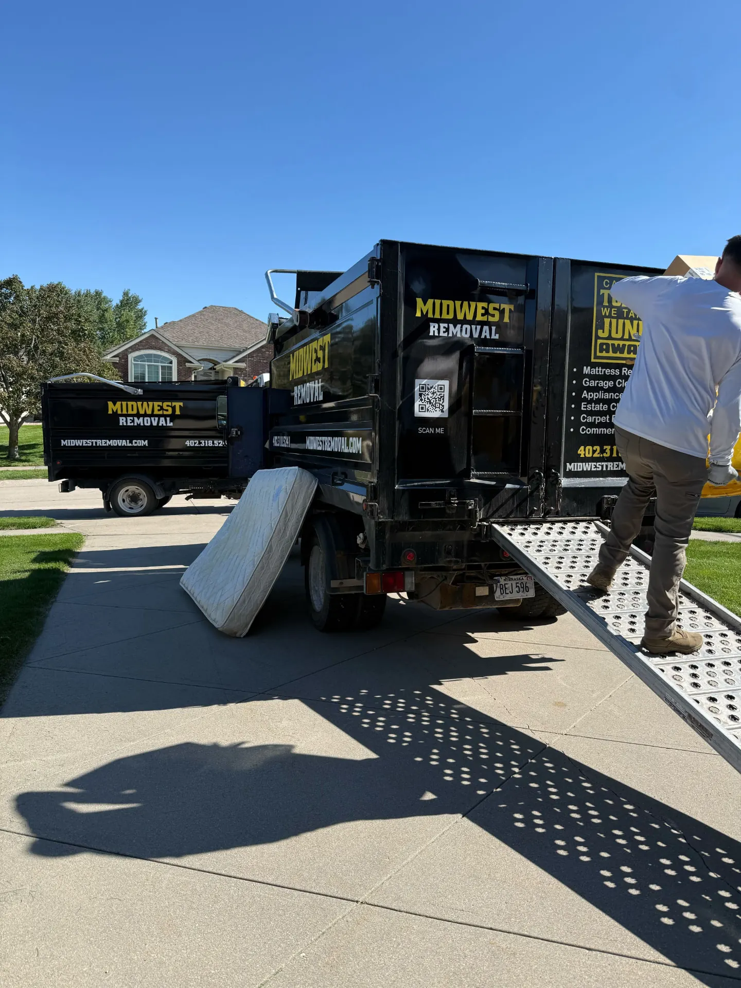 Midwest Removal trucks on a driveway during a mattress and cleanout pickup