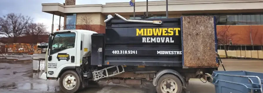 Junk removal crew carrying household items out to a truck in Omaha