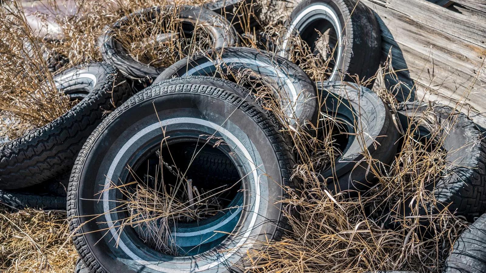 Stack of worn out car tires waiting for disposal outside an Omaha garage
